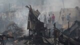 Residents return to their still smoldering homes after a fire broke out at a slum area in Pasay, south of Manila, Philippines. Pasay City Fire Marshall Major Douglas Guiyab said about 250 houses were gutted in the area and the cause of the fire is still being determined.