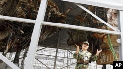 FILE - A South Korean naval officer talks in front of wreckage of the salvaged naval vessel Cheonan, May 19, 2010.