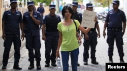 A supporter of presidential candidate Mohamed Nasheed, who was ousted as president in 2012, holds up a placard during a protest against the Maldives police, in Male, Oct. 19, 2013. 