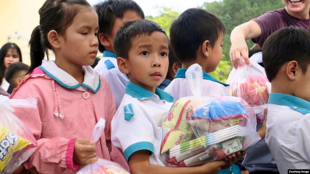 Ảnh tư liệu - Học sinh một trường tiểu học nhận quà từ các thiện nguyện viên