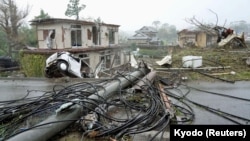 Rumah-rumah, mobil-mobil, dan tiang-tiang listrik yang rusak akibat angin kencang Taifun Hagibis di Ichihara, timur Tokyo, Jepang, 12 Oktober 2019. (Foto: Kyodo)