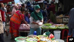 Seorang pedagang ikan mengenakan masker di tengah pandemi corona di sebuah pasar di Jakarta, 24 Juni 2020. (Foto: dok).