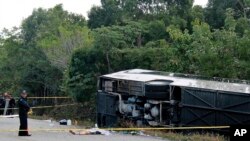 Le corps sans vie d'un passager à côté du bus qui s'est renversé à Mahahual au Mexique, mardi 19 décembre 2017.