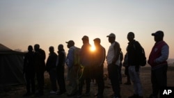 FILE - Voters wait in a queue to cast their votes at a polling station in Harare, Zimbabwe, Wednesday, Aug. 23, 2023.
