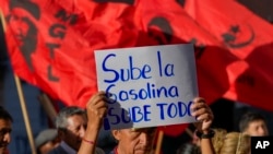 Un manifestante sostiene un cartel durante una protesta antigubernamental contra el aumento de los precios del combustible, en Quito, Ecuador, el 12 de junio de 2024.