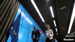 FILE - European Council President Charles Michel and European Commission President Ursula von der Leyen leave following a virtual summit with Chinese President Xi Jinping in Brussels, Belgium, June 22, 2020.