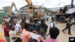 FILE-Rescue workers carry a survivor from the rubble of a collapsed building belonging to the Synagogue Church of All Nations in Lagos, Nigeria, Sept. 13, 2014.