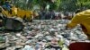 A Manila City Hall employee throws pirated DVDs (Digital Video Discs) onto the path of the steamrollers as they are destroyed, file photo. 