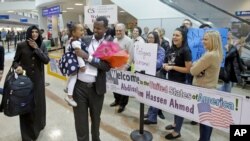 ARCHIVO - Abdisellam Hassen Ahmed, un refugiado somalí que quedó en el limbo luego que el presidente Donald Trump prohibió temporalmente el ingreso de refugiados, camina con su esposa y su hija en el aeropuerto de Salt Lake City. Feb. 10 de 2017. 