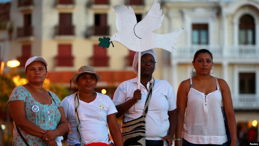 FILE - Activists take part during a demonstration to protest violence against women in Cartagena, Colombia, Oct. 27, 2016. 