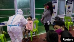 A child reacts after getting swabbed for a free coronavirus disease (COVID-19) test at a gymnasium in Navotas City, Metro Manila, Philippines, Aug. 7, 2020.