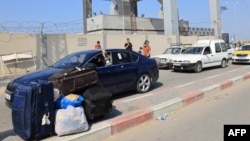  گذرگاه مرزی رفح. پس از حملات اسرائیل به نوار غزه، فلسطینی‌ها با گذرنامه‌های خارجی به امید عبور از مرز و ورود به خاک مصر در صف منتظر هستند - ۲۲ مهر ۱۴۰۲
