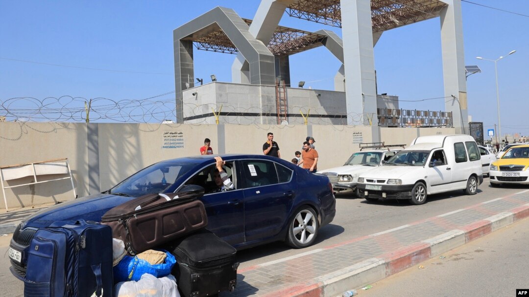 Palestinians with foreign passports arrive at the Rafah gate hoping to cross into Egypt as Israel's attacks on the Gaza Strip continues on October 14, 2023.
