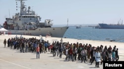 Migrants are disembarked from the Italian navy ship Vega in the Sicilian harbor of Augusta, southern Italy, May 4, 2015.