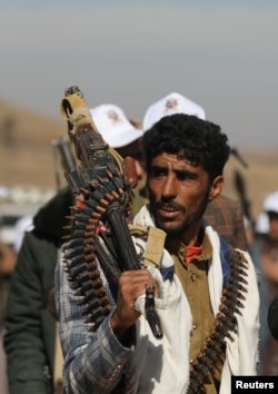 FILE - A tribesman loyal to the Houthis carries a machine gun during a military parade for new tribal recruits amid escalating tensions with the U.S.-led coalition in the Red Sea, in Bani Hushaish, Yemen January 22, 2024.