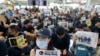 Anti-extradition bill protesters hold up placards for arriving travelers during a protest at the Hong Kong International Airport in Hong Kong, Aug. 9, 2019. 