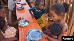 Children eat a meal at the Avotse feeding program that benefits malnourished children with hot meals in Maropia Nord village in the region of Anosy, southern Madagascar, Sept. 30, 2021. 