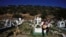 A musician sits on a tomb in the Valle de Chalco municipal cemetery as people begin to arrive to pay their respects to their dead, on the outskirts of Mexico City, Oct. 31. 2021.