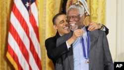 FILE - President Barack Obama reaches up to present a 2010 Presidential Medal of Freedom to basketball hall of fame member, former Boston Celtics coach and captain Bill Russell on Feb. 15, 2011. 