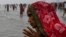 A Hindu pilgrim in India prays as she takes a holy dip at the confluence of Ganges and the Bay of Bengal during the Gangasagar Mela on the occasion of Makar Sankranti, Jan. 14, 2022. 