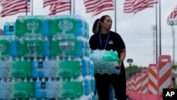 Personal de la iglesia Lakewood Church reparte botellas de agua entre la población y opera un centro de refrigerio en Houston, Texas, el 9 de julio de 2024.