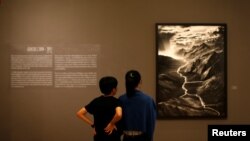 People attend an exhibition of Brazilian photographer Sebastiao Salgado titled "The World Through His Eyes" at the Bangkok Art and Culture Center in Bangkok, Thailand, Feb. 10, 2017.