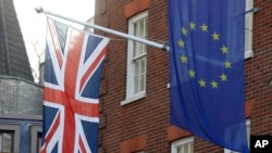 Bendera Uni Eropa (kanan), dan bendera Inggris di Kantor Penghubung Parlemen Eropa di London, 21 Januari 2020. Inggris akan meninggalkan Uni Eropa 31 Januari 2020. (AP Photo / Kirsty Wigglesworth)
