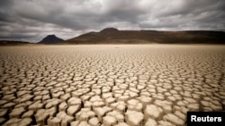 FILE - Clouds gather but produce no rain as cracks are seen in the dried up municipal dam in drought-stricken Graaff-Reinet, South Africa, Nov. 14, 2019. 