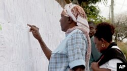 Des kényanes cherchent leur nom sur les listes affichées devant un bureau de vote à Nairobi, Kenya, 7 août 2017.