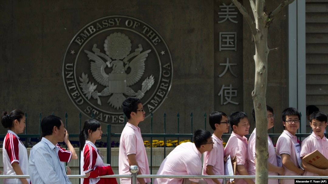 FILE - Chinese students wait outside the U.S. Embassy for their visa application interviews in Beijing, China. The Trump administration may expel thousands of Chinese graduate students enrolled at universities in the U.S. 