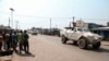 FILE - Residents watch as a U.N. Multidimensional Integrated Stabilization Mission in the Central African Republic (MINUSCA) armored personnel carrier patrols after attacks in Begoua, a northern district of Bangui, Jan. 13, 2021.