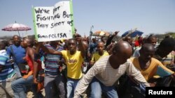 Para buruh tambang platina melakukan aksi protes dengan mogok kerja dan berunjuk rasa di pertambangan Anglo-American Platinum (AMPLATS) dekat Rustenburg, Afrika Selatan (5/10). 