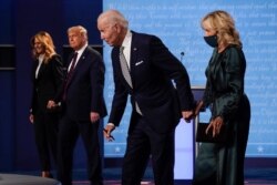 From l-r, first lady Melania Trump, President Donald Trump, Democratic presidential candidate former Vice President Joe Biden and Jill Biden, walk off stage at the conclusion of the first presidential debate, Sept. 29, 2020.