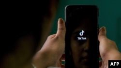 FILE - A mobile phone user opens the Chinese-owned video-sharing 'TikTok' app on a device in Bangalore, India, June 30, 2020.