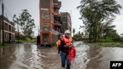 FILE — Members of the Kenya Red Cross asses an area affected by floods while looking for residents trapped in their homes following torrential rains in Kitengela, on May 1, 2024.