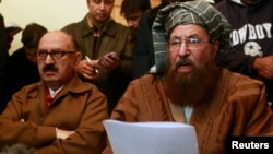 Maulana Sami ul-Haq (R), one of the Taliban negotiators, reads a joint statement with Irfan Siddiqui, a government negotiator, during a news conference in Islamabad, Feb. 6, 2014.