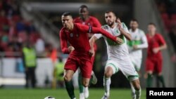 Cristiano Ronaldo beradu dengan Salim Boukhanchouche dalam pertandingan persahabatan antara Portugal dan Aljazair, di Estadio da Luz, Lisbon, Portugal, 7 Juni 2018.