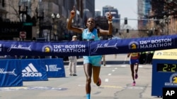 Peres Jepchirchir, of Kenya, crosses the finish line to win the women's division of the 126th Boston Marathon, Monday, April 18, 2022, in Boston. (AP Photo/Winslow Townson)