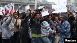 A policeman attempts to control protesters chanting slogans during a demonstration over what they say is unfair distribution of wealth in the country at Meskel Square in Ethiopia's capital Addis Ababa, Aug. 6, 2016.