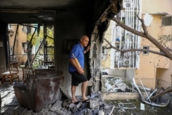 Un miembro de la familia Sror inspecciona los daños de su apartamento después de ser alcanzado por un cohete disparado desde la Franja de Gaza durante la noche, en Petah Tikva, en el centro de Israel, el jueves 13 de mayo de 2021.