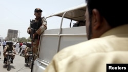 FILE - A soldier stands guard in Karachi, Pakistan, May 13, 2015. The military has been accused by opposition parties in Pakistan of kidnapping a senior police official to force him to arrest an opposition leader.