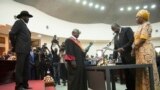 FILE - South Sudan's President Salva Kiir Mayardit, left, swears in Dr. Riek Machar as the first vice president of the country, in Juba, Feb. 22, 2020.