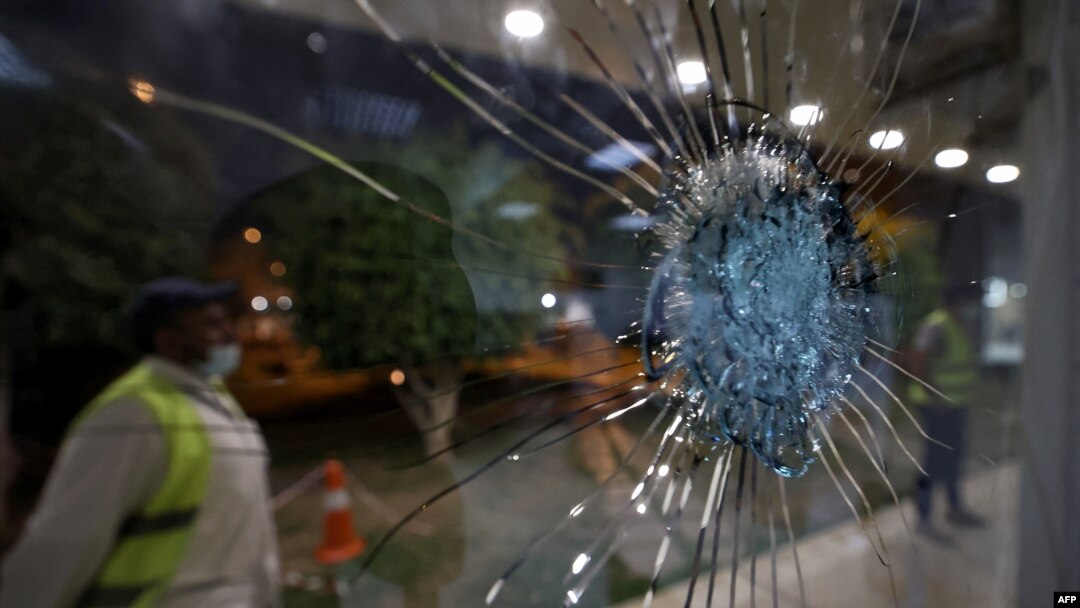Saudi airport personnel are pictured behind shrapnel-riddled glass at Abha airport in the popular mountain resort of Abha in the southwest of Saudi Arabia on August 31, 2021.