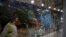 Saudi airport personnel are pictured behind shrapnel-riddled glass at Abha airport in the popular mountain resort of Abha in the southwest of Saudi Arabia on August 31, 2021.