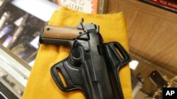 Una pistola semiautomática y un porta-pistolas se exhiben en una tienda de armas de Little Rock, Arkansas. Foto de Archivo. 