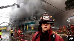 Firefighters try to extinguish a fire at a warehouse in Lima, Peru, June 23, 2017. 