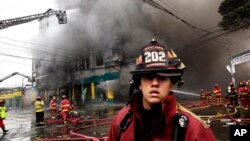 Firefighters try to extinguish a fire at a warehouse in Lima, Peru, June 23, 2017. 