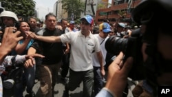 El líder opositor Henrique Capriles saluda a simpatizantes durante una manifestación de los profesionales de la salud el lunes 22 de mayo.