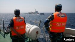 FILE: Vietnamese Marine Guard officers monitor a Chinese coast guard vessel (top) on the South China Sea, about 210 km (130 miles) offshore of Vietnam, May 15, 2014.