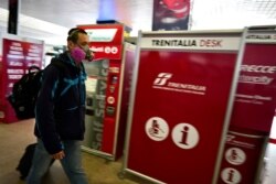 A traveler wears a mask inside Rome's Termini train station, Tuesday, March 10, 2020.